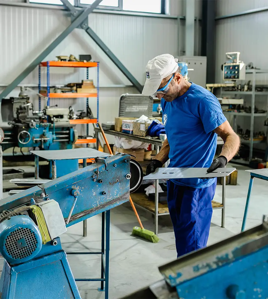 Man Using Measuring Tape in Factory Setting Man Using Measuring Tape in Factory Setting
